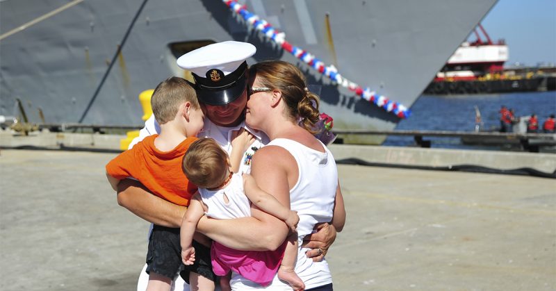 Sailor hugging family after getting off boat
