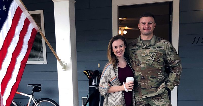 military spouse standing with service member outside home