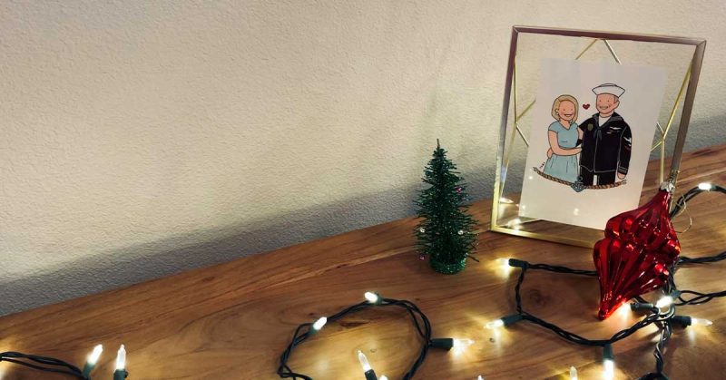 Christmas lights on a table with a framed picture of a couple.