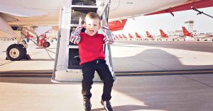 Kristi’s son posing outside of a military airplane