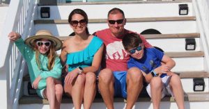 Kristi and her family on the steps of a beach house 