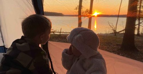 Sydney’s two toddlers in their camping tent looking out at the sunset