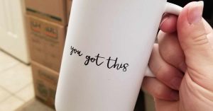 “You got this” mug with packed moving boxes in the background.