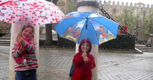 Two kids with umbrellas.