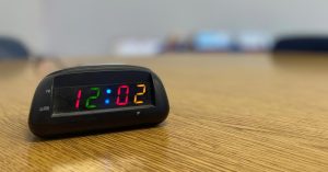 A clock that reads 12:02, the numbers are in different colors.