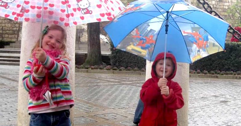 Lizann’s two kids holding umbrellas.