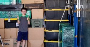 Lizann’s son standing in front of moving boxes