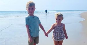 Two children holding hands on the beach