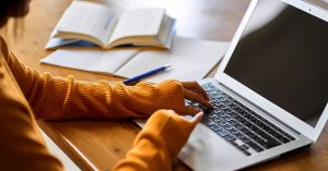 Hands typing on computer