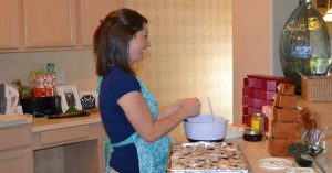 Woman making cinnamon buns in kitchen