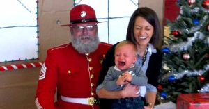 Kid crying with Santa and mom 