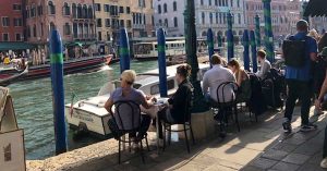 Tables, chair, and waterway in Italy