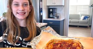 Kristi’s daughter holding a pizza