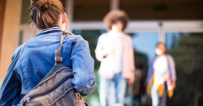 Young woman walking up college stairs