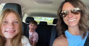 Mom and children smiling in car