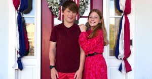 Kristi’s children in front of a door smiling