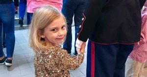 Kristi’s child holding her father’s hand