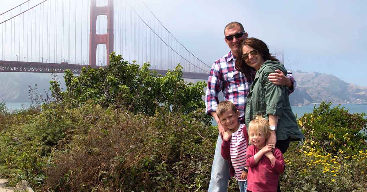 Kristi’s family outside posing in front of a bridge