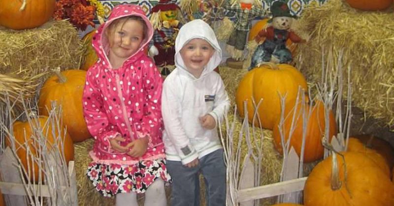 Children posing in front of pumpkins at commissary