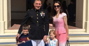 Kristi and her service member stand outside a building, holding hands with their children