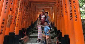 Kristi’s family posing together beneath a bright orange pathway.