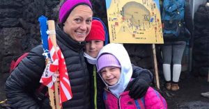 Kristi and her two children dressed in cold-weather clothing smiling together during a winter outing.