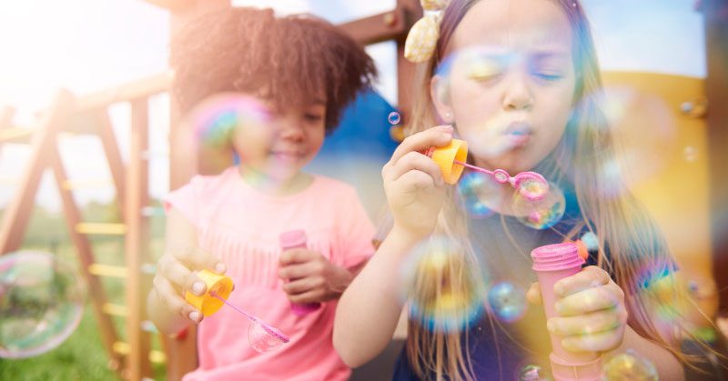 Two children blowing bubbles