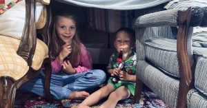 Two children playing in a fort