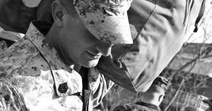 A closeup of a service member holding his pack