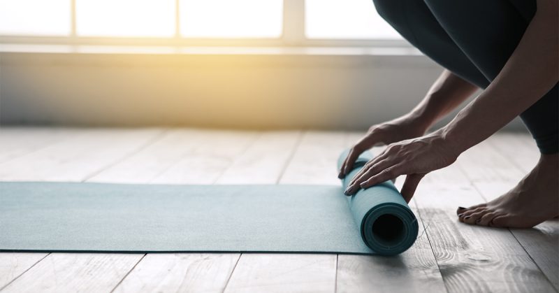 woman rolling yoga mat
