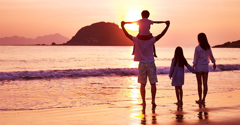 Family enjoying the beach during sunset