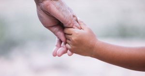 Closeup of a parent holding a child's hand