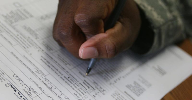 A closeup of a man filling out his tax forms